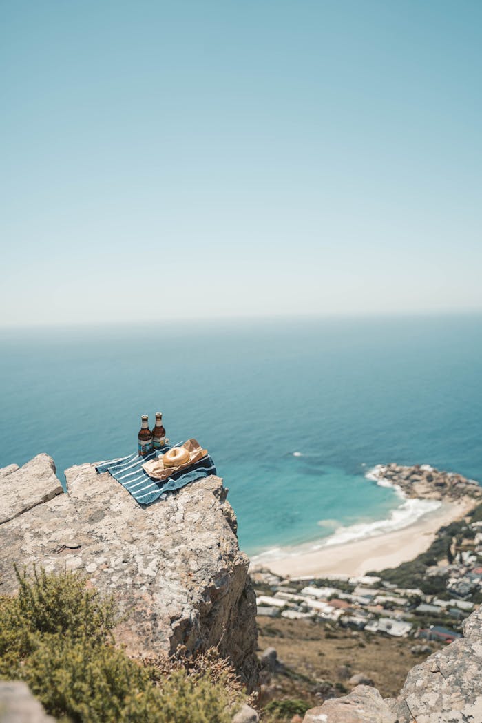 Picnic setup with drinks on a cliff overlooking the ocean near Cape Town.